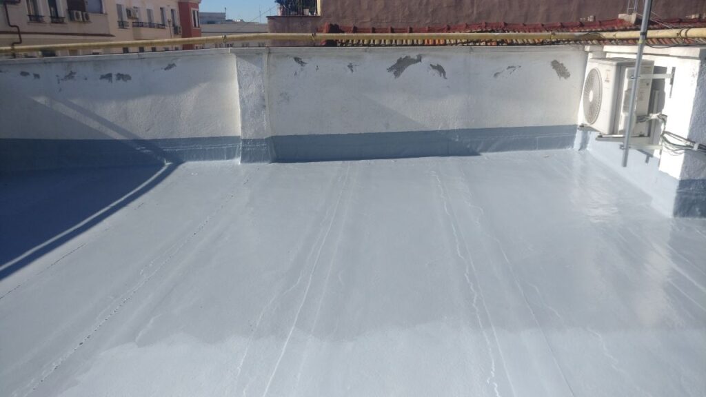 Picture of my building's rooftop receiving a new waterproofing treatment past winter. It's an empty surface covered with plastic paint, surrounded by walls that could make up for a basin